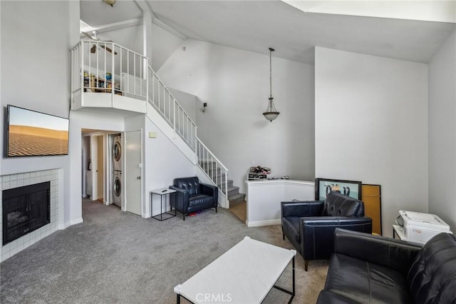 18107 Erik Ct Unit 462, Canyon Country, CA 91387 - living room featuring stacked washer / drying machine, carpet, stairway, high vaulted ceiling, and a fireplace