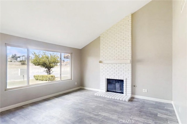 17175 Micallef St, Fontana, CA 92336 - unfurnished living room featuring lofted ceiling, wood finished floors, a fireplace, and baseboards