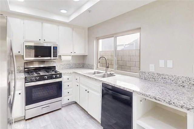 17175 Micallef St, Fontana, CA 92336 - kitchen with stainless steel appliances, a sink, a tray ceiling, white cabinets, and recessed lighting