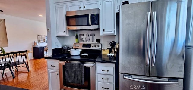 16408 Vista Roma Cir Unit Ci116, Huntington Beach, CA 92649 - kitchen with appliances with stainless steel finishes, dark countertops, light wood-type flooring, white cabinetry, and recessed lighting