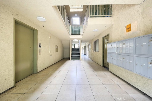 70 N Catalina Ave Unit 306, Pasadena, CA 91106 - view of property's community featuring a high ceiling, mail area, a textured wall, and stairs