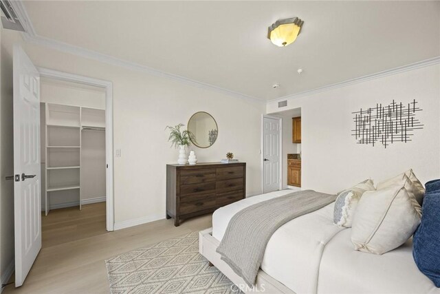 70 N Catalina Ave Unit 306, Pasadena, CA 91106 - bedroom featuring light wood finished floors, a spacious closet, crown molding, baseboards, and a closet