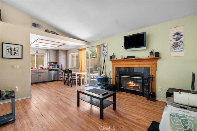 20015 Gilbert Dr, Canyon Country, CA 91351 - living area with vaulted ceiling, healthy amount of natural light, light wood-style floors, a high end fireplace, and baseboards