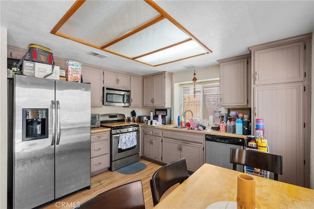 20015 Gilbert Dr, Canyon Country, CA 91351 - kitchen featuring stainless steel appliances, a sink, light wood-type flooring, and light countertops