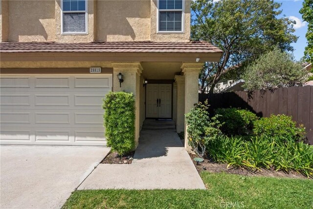 20015 Gilbert Dr, Canyon Country, CA 91351 - doorway to property featuring stucco siding, a garage, and concrete driveway