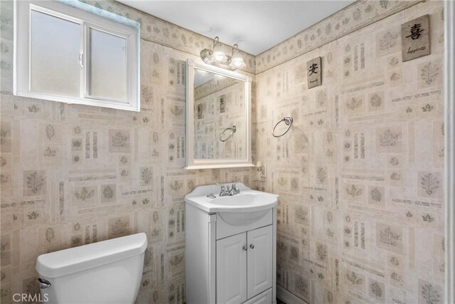 20015 Gilbert Dr, Canyon Country, CA 91351 - half bathroom with vanity, toilet, and wallpapered walls