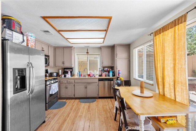 20015 Gilbert Dr, Canyon Country, CA 91351 - kitchen with stainless steel appliances, a sink, light wood-style floors, gray cabinets, and light countertops