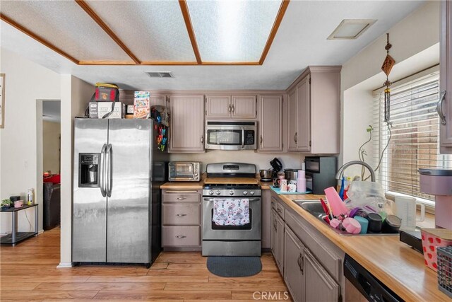 20015 Gilbert Dr, Canyon Country, CA 91351 - kitchen with stainless steel appliances, light wood-style flooring, light countertops, and a sink