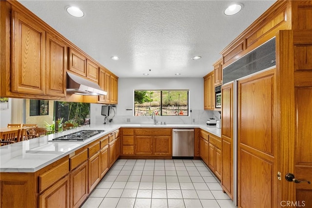 52 Hidden Valley Rd, Monrovia, CA 91016 - kitchen featuring appliances with stainless steel finishes, under cabinet range hood, a sink, brown cabinets, and recessed lighting