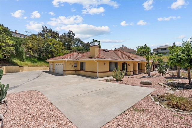 52 Hidden Valley Rd, Monrovia, CA 91016 - mediterranean / spanish-style home with driveway, an attached garage, a tile roof, stucco siding, and a chimney