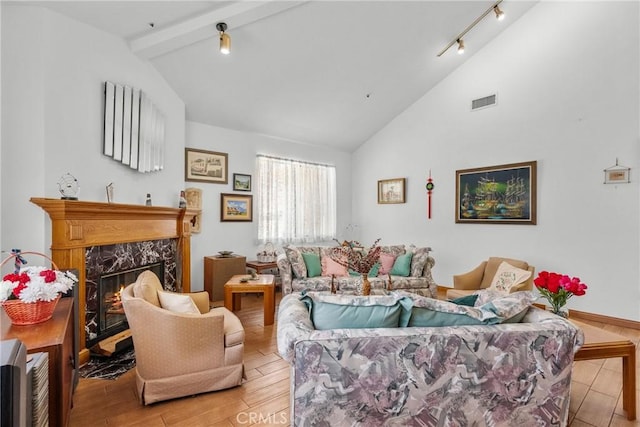 52 Hidden Valley Rd, Monrovia, CA 91016 - living area with track lighting, a fireplace, beam ceiling, light wood finished floors, and high vaulted ceiling