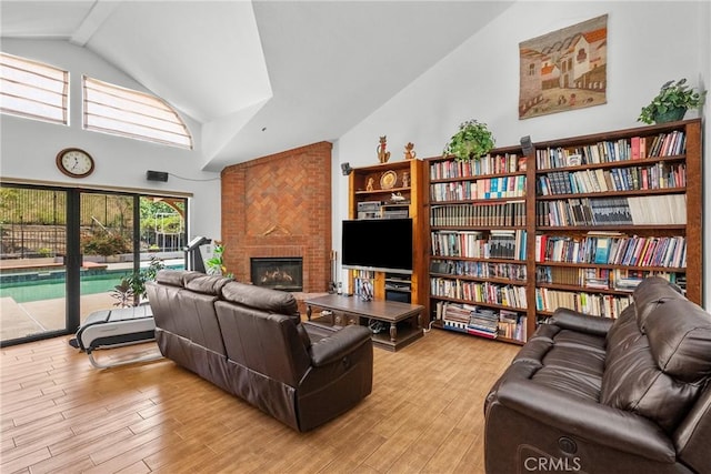 52 Hidden Valley Rd, Monrovia, CA 91016 - living area featuring high vaulted ceiling, a fireplace, and light wood-style flooring