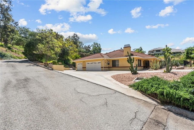 52 Hidden Valley Rd, Monrovia, CA 91016 - mediterranean / spanish house with a tiled roof, a garage, a chimney, driveway, and stucco siding