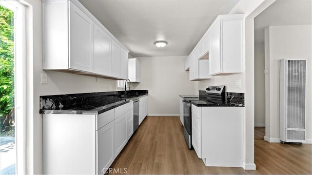 3637 Stauss Ave, Oroville, CA 95966 - kitchen with appliances with stainless steel finishes, a heating unit, light wood-type flooring, and baseboards