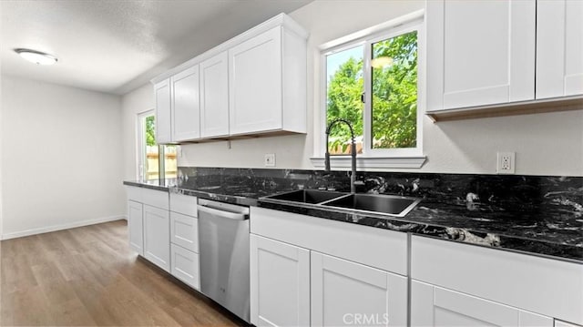 3637 Stauss Ave, Oroville, CA 95966 - kitchen with stainless steel dishwasher, a sink, light wood finished floors, white cabinetry, and baseboards