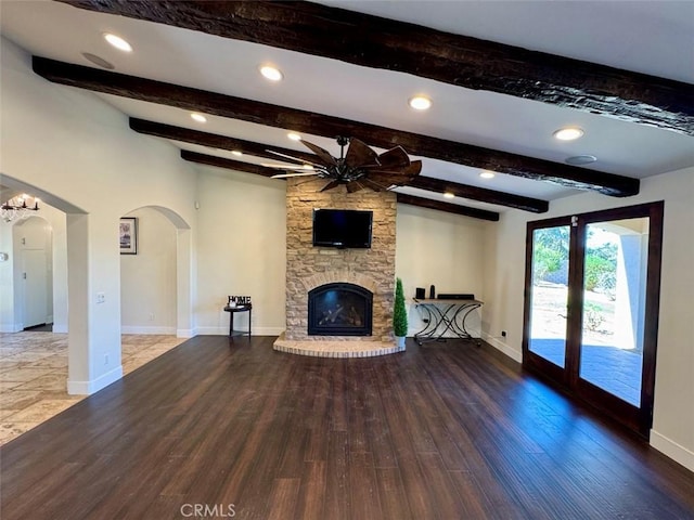 1415 Via Vallarta, Riverside, CA 92506 - unfurnished living room with arched walkways, wood finished floors, a large fireplace, a ceiling fan, and beamed ceiling