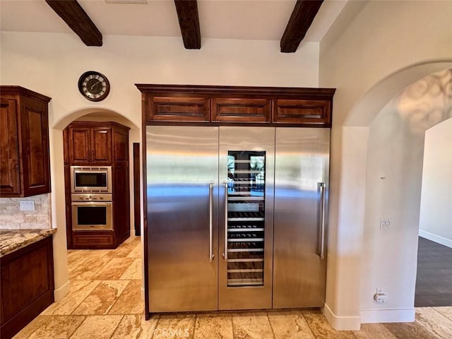 1415 Via Vallarta, Riverside, CA 92506 - kitchen with stainless steel appliances, beam ceiling, arched walkways, light stone countertops, and dark brown cabinets