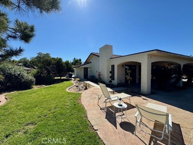 1415 Via Vallarta, Riverside, CA 92506 - rear view of property with a yard, stucco siding, and a patio