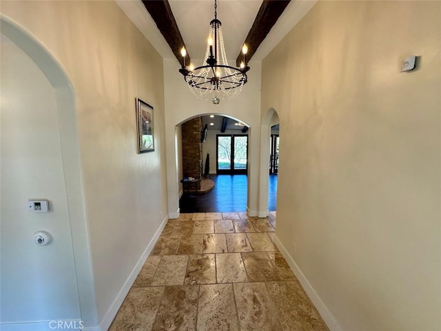 1415 Via Vallarta, Riverside, CA 92506 - corridor with stone tile floors, arched walkways, beam ceiling, a high ceiling, and a chandelier