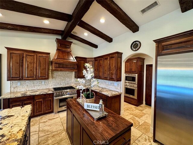 1415 Via Vallarta, Riverside, CA 92506 - kitchen with stainless steel appliances, stone tile floors, custom range hood, recessed lighting, and decorative backsplash