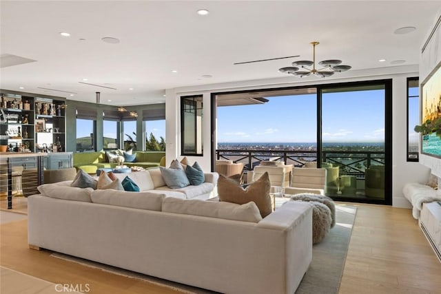 1010 Kings Rd, Newport Beach, CA 92663 - living area with a chandelier, wood finished floors, recessed lighting, a bar, and expansive windows