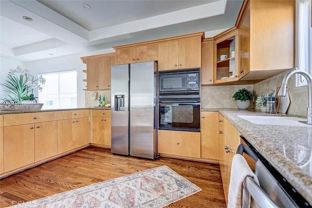 602 N Juanita Ave Unit A, Redondo Beach, CA 90277 - kitchen with black appliances, a sink, light wood-style floors, decorative backsplash, and light stone countertops