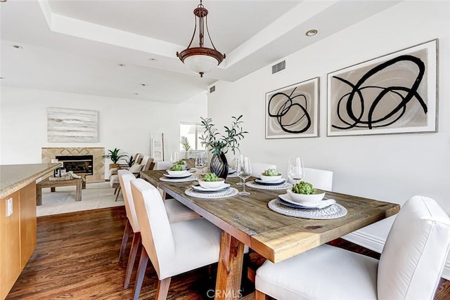 602 N Juanita Ave Unit A, Redondo Beach, CA 90277 - dining space with a fireplace with raised hearth, dark wood-type flooring, and a tray ceiling