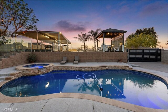 5080 Pinto Pl, Norco, CA 92860 - pool at dusk with a fenced backyard, a patio area, and a pool with connected hot tub