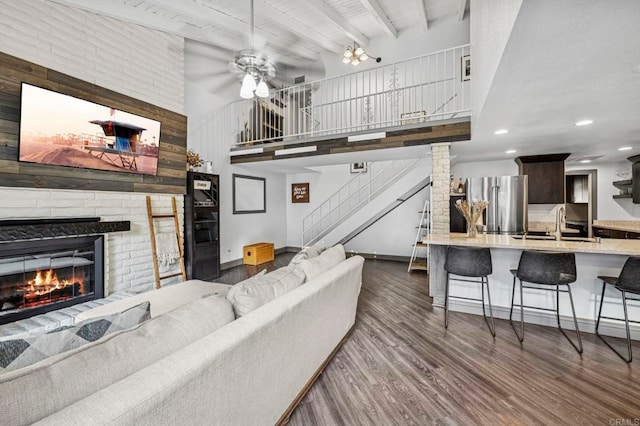 3404 Oak Cliff Dr Unit 8, Fallbrook, CA 92028 - living room featuring a ceiling fan, dark wood-style floors, stairway, a towering ceiling, and a fireplace