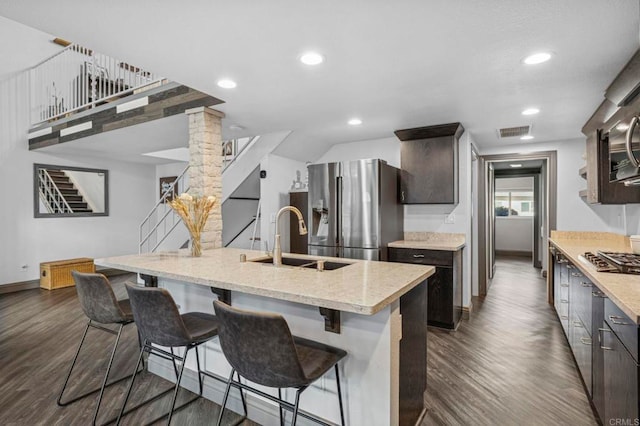 3404 Oak Cliff Dr Unit 8, Fallbrook, CA 92028 - kitchen featuring appliances with stainless steel finishes, a sink, ornate columns, dark wood-style floors, and a breakfast bar