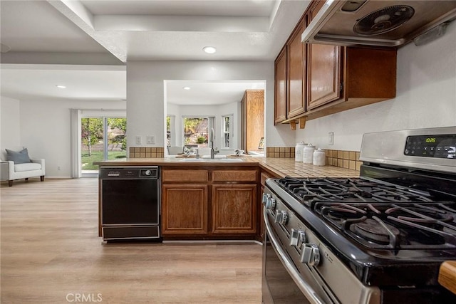 915 W Solano St, Upland, CA 91784 - kitchen featuring stainless steel gas range oven, dishwasher, extractor fan, light wood-style flooring, and brown cabinets