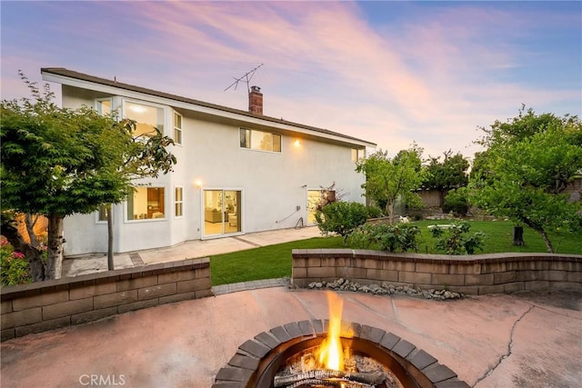 915 W Solano St, Upland, CA 91784 - patio terrace at dusk with an outdoor fire pit, a patio area, and a lawn