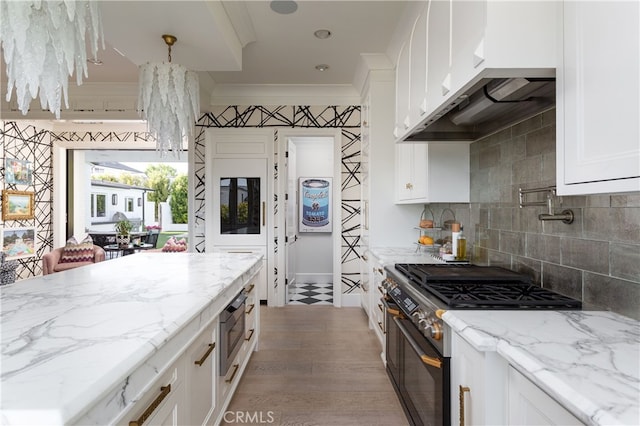 1110 Kings Rd, Newport Beach, CA 92663 - kitchen featuring appliances with stainless steel finishes, white cabinets, light stone counters, wood finished floors, and ornamental molding