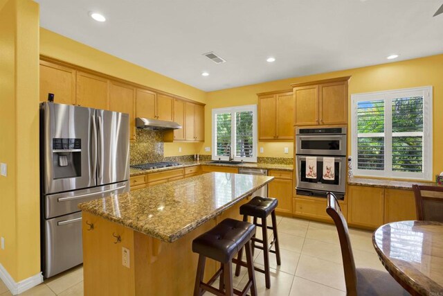 907 Rockwell Springs Ct, Escondido, CA 92025 - kitchen with appliances with stainless steel finishes, under cabinet range hood, a sink, a kitchen island, and stone counters