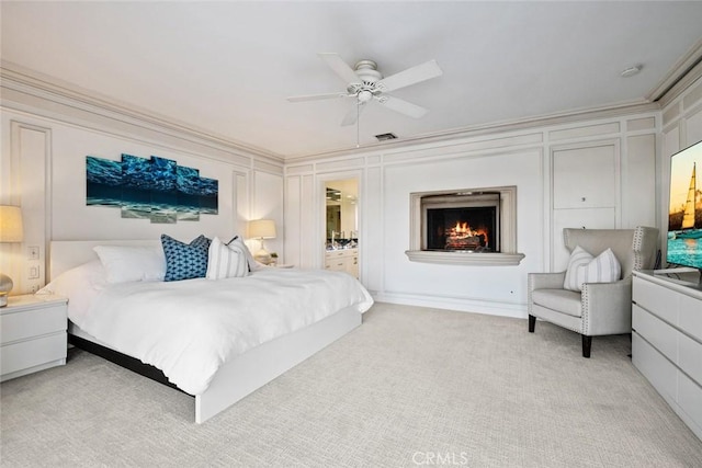 218 Evening Star Ln, Newport Beach, CA 92660 - bedroom featuring a decorative wall, light carpet, a lit fireplace, ornamental molding, and a ceiling fan