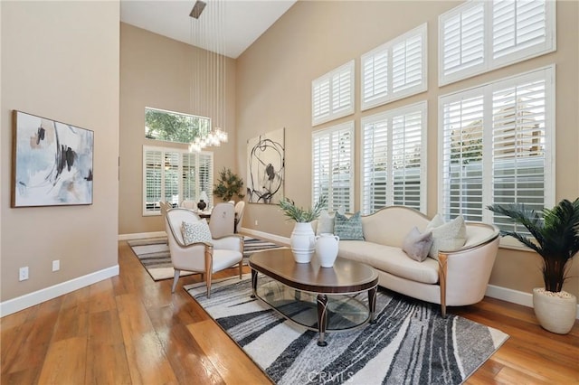 24261 Ernest Johnson Cir, Yorba Linda, CA 92887 - living room with baseboards, wood finished floors, a high ceiling, and a chandelier