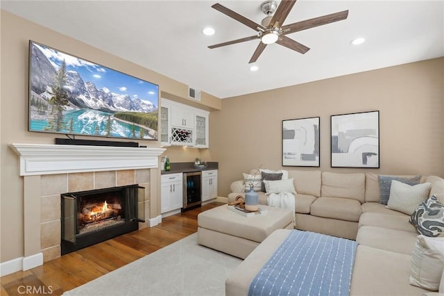 24261 Ernest Johnson Cir, Yorba Linda, CA 92887 - living area with wine cooler, recessed lighting, a tiled fireplace, a ceiling fan, and wood finished floors