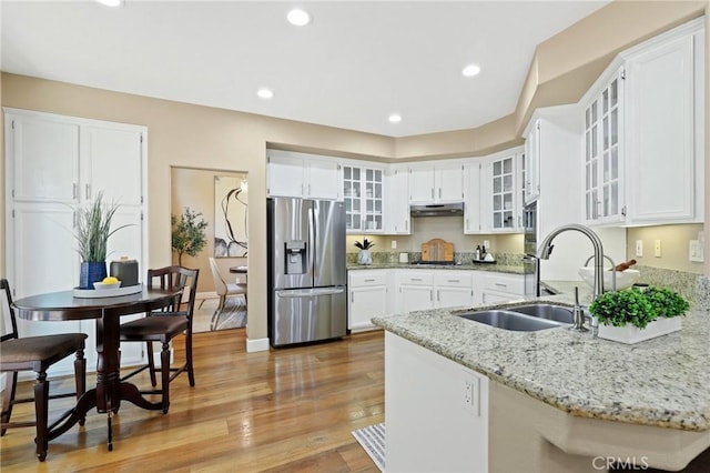 24261 Ernest Johnson Cir, Yorba Linda, CA 92887 - kitchen with stainless steel appliances, under cabinet range hood, a sink, light stone countertops, and white cabinetry