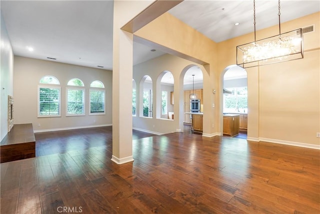 12160 Glines Ct, Tustin, CA 92782 - unfurnished living room with dark wood-type flooring, baseboards, arched walkways, a chandelier, and recessed lighting