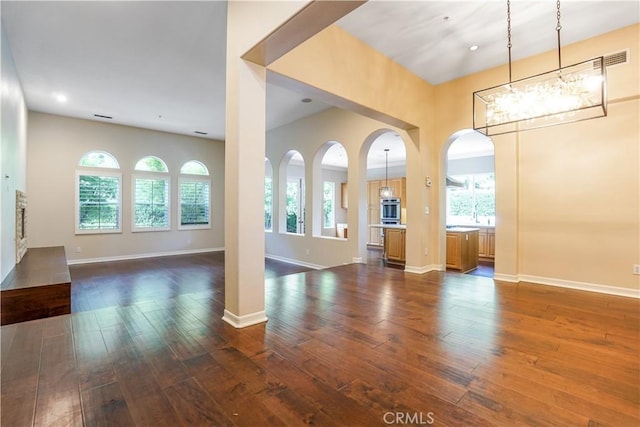 12160 Glines Ct, Tustin, CA 92782 - unfurnished living room featuring dark wood finished floors, arched walkways, a chandelier, and recessed lighting
