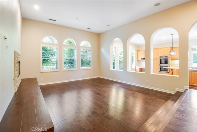12160 Glines Ct, Tustin, CA 92782 - unfurnished living room featuring plenty of natural light, dark wood-type flooring, and a stone fireplace