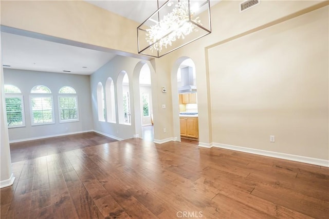 12160 Glines Ct, Tustin, CA 92782 - unfurnished room featuring hardwood / wood-style flooring, arched walkways, and a chandelier