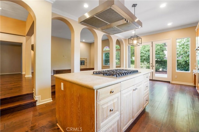 12160 Glines Ct, Tustin, CA 92782 - kitchen featuring wall chimney exhaust hood, stainless steel gas cooktop, dark wood-style flooring, crown molding, and decorative light fixtures