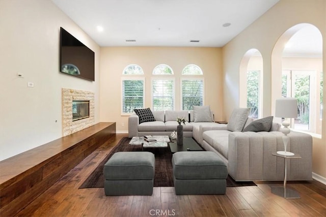 12160 Glines Ct, Tustin, CA 92782 - living room with hardwood / wood-style floors, arched walkways, and a stone fireplace