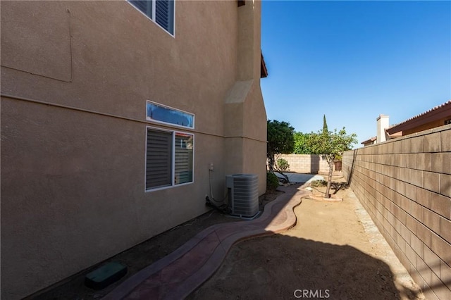 8961 Newcastle Ave, Hesperia, CA 92344 - view of side of home featuring a fenced backyard, stucco siding, and central AC unit