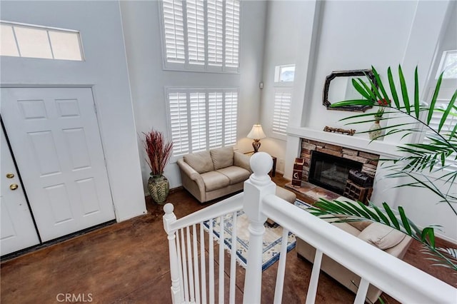 8961 Newcastle Ave, Hesperia, CA 92344 - living room featuring a towering ceiling, concrete flooring, and a stone fireplace
