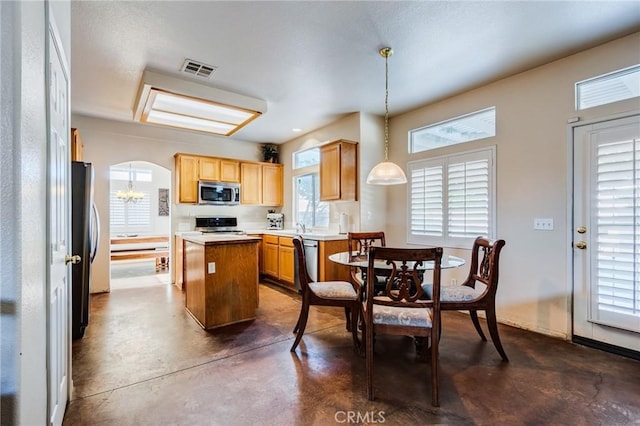 8961 Newcastle Ave, Hesperia, CA 92344 - kitchen with stainless steel microwave, a kitchen island, concrete flooring, and plenty of natural light
