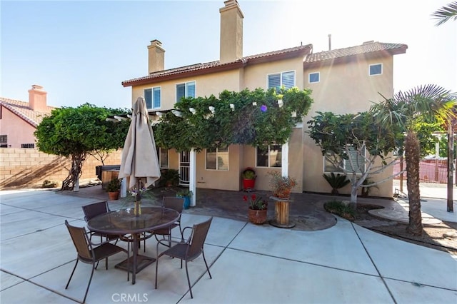 8961 Newcastle Ave, Hesperia, CA 92344 - back of house with a patio, stucco siding, a chimney, and outdoor dining area