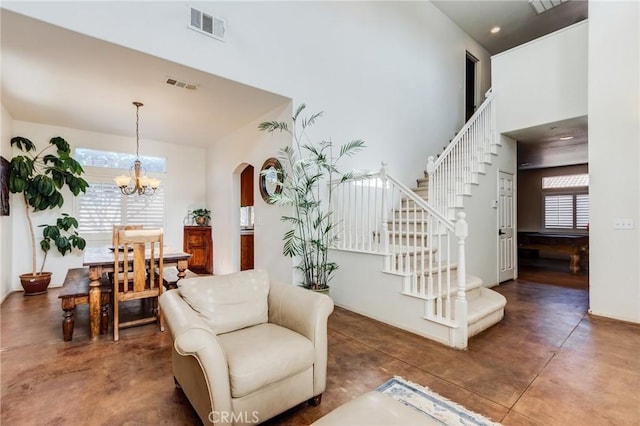 8961 Newcastle Ave, Hesperia, CA 92344 - living area with concrete floors, stairway, a chandelier, arched walkways, and a towering ceiling
