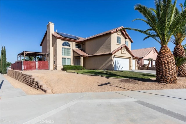 8961 Newcastle Ave, Hesperia, CA 92344 - view of front of property featuring driveway, roof mounted solar panels, a garage, stucco siding, and a chimney